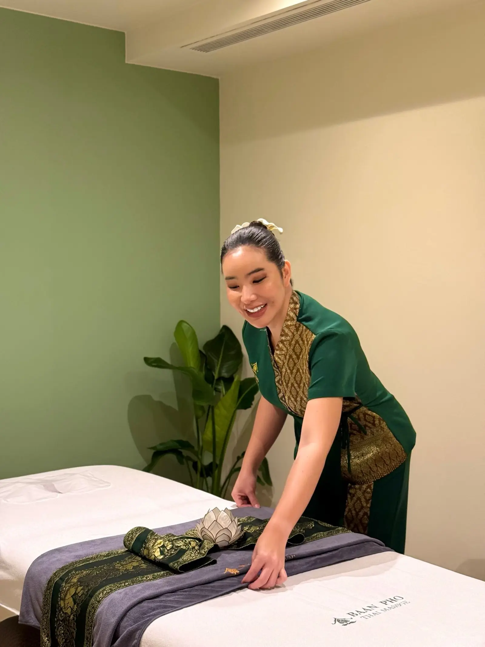 Terapeuta de Baan Pho preparando la camilla con esmero y dedicación